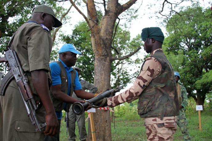 Un membre du groupe armé RJ Sayo remet symboliquement son arme aux techniciens chargés du désarmement, à la sortie de Paoua, dans l’ouest de la Centrafrique, le 30 mai 2019.