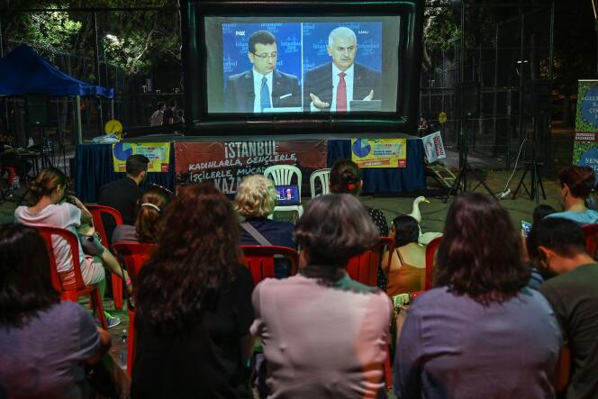 Des Stambouliotes regardent un débat télévisé entre Binali Yildirim (à droite), du Parti de la justice et du développement (AKP), au pouvoir en Turquie, et Ekrem Imamoglu (à gauche), du Parti républicain du peuple (CHP), tous deux candidats à la mairie d’Istanbul, le 16 juin 2019.