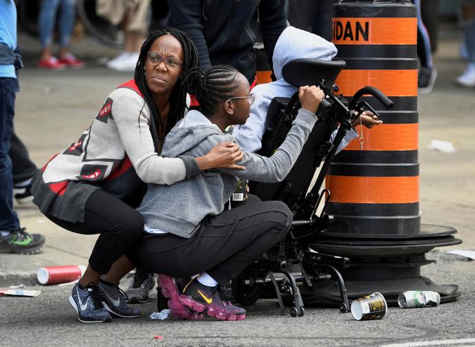 Des personnes se protègent après l’annonce de coups de feu près du Nathan Phillips Square à Toronto, lors de la parade des Raptors, le 17 juin.