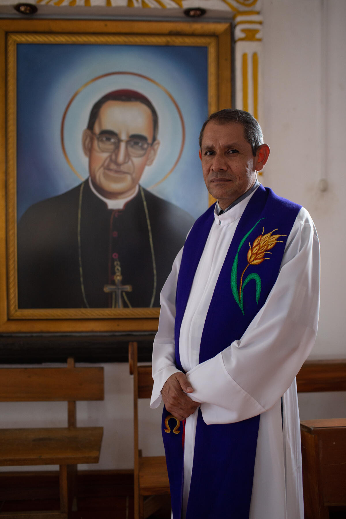 Le prêtre Ernesto Rueda Moreno, devant le portrait de saint Oscar Romero, dans l’église de San Pedro Apostol, à El Estor, le 28 mars. Saint Oscar Romero, défenseur des droits de l’homme, a été abattu lors d’une messe donnée au Salvador, en 1980.
