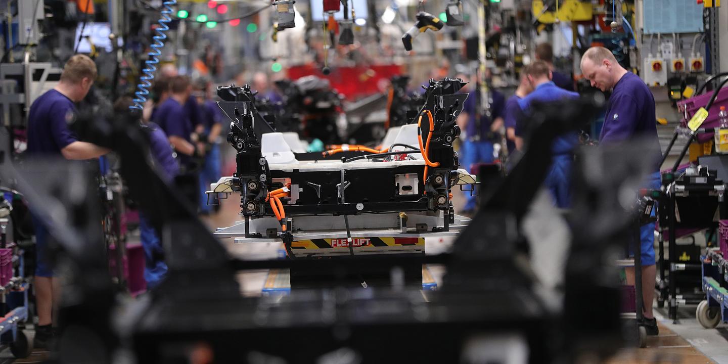 Employees work on BMW i3 electric automobile chassis fitted with battery packs on the assembly line at the Bayerische Motoren Werke AG factory in Leipzig, Germany, on Thursday, March 14, 2019. Chancellor Angela Merkel's plan to hatch a German battery-cell industry from scratch is gaining momentum as Europe's biggest economy tries to lower emissions while keeping Chinese automobile competition at bay. Photographer: Krisztian Bocsi/Bloomberg via Getty Images