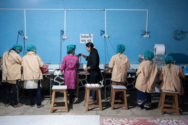 Une trentaine de femmes travaillent à fabriquer des serviettes hygiéniques, au sein de l’atelier de Chaya Kakade, à Pardhewadi, le 14 juin.
