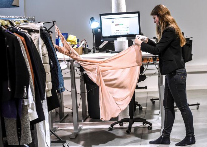 Vérification d’une robe avant sa vente en ligne, au centre logistique de la société « Vestiaire Collective », à Tourcoing (Nord), en décembre 2017.