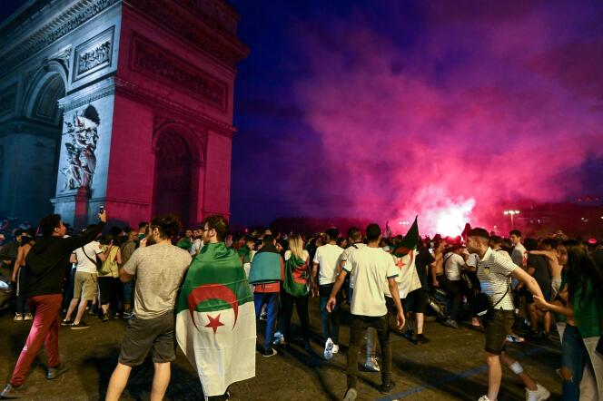 Des supporteurs de l’équipe d’Algérie fêtent la victoire de leur équipe face à la Côte d’Ivoire, près de l’Arc de triomphe à Paris, le 11 juillet.