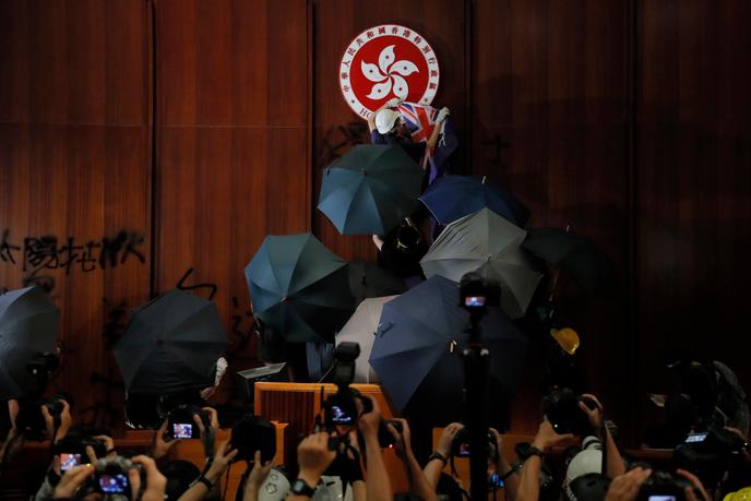 Des manifestants détériorent le Conseil législatif en couvrant les murs de graffitis, à Hongkong, le 1er juillet.