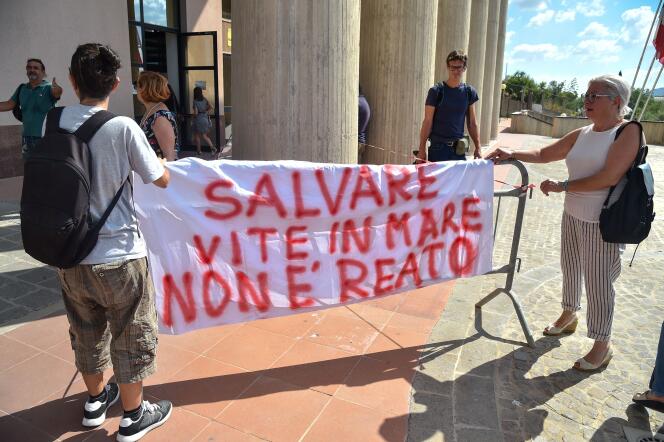 Des manifestants brandissent une banderole devant le tribunal d’Agrigente (Italie). Il y est inscrit « sauver des vies en mer n’est pas un crime ».