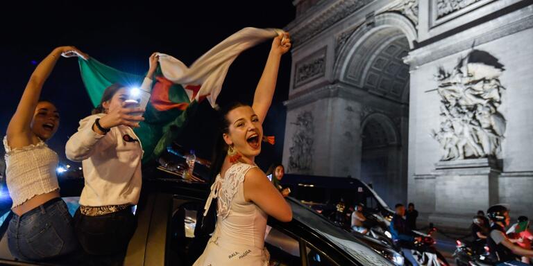 Algeria's supporters waves Algeria's national flag as they celebrate in front of the Arc de Triomphe on the Champs Elysee Avenue in Paris, after Algeria won 1-0 the 2019 Africa Cup of Nations (CAN) final football match between Algeria and Senegal, on July 19, 2019. / AFP / Bertrand GUAY
