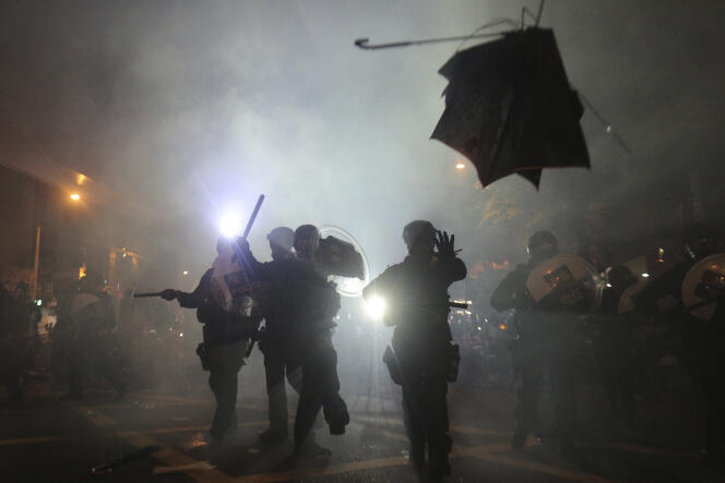 La police fait usage de gaz lacrymogènes pour disperser la foule, à Hongkong, dans la soirée du 21 juillet.