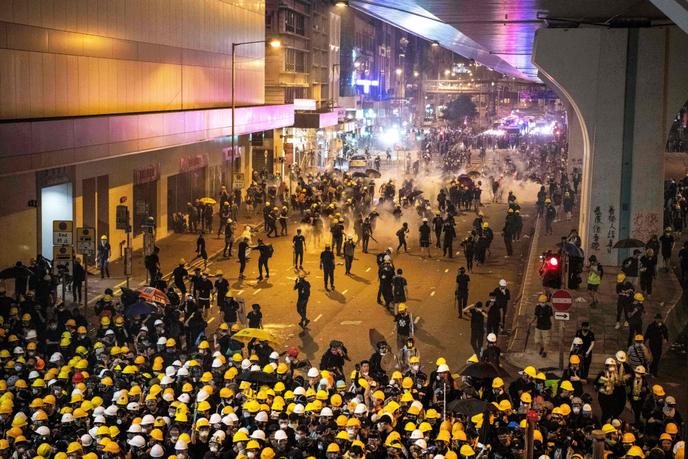 La police fait usage de gaz lacrymogènes pour disperser la foule, à Hongkong, dans la soirée du 21 juillet.
