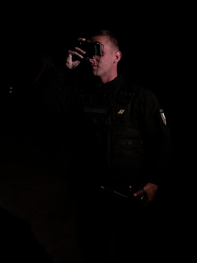 Un officier de la gendarmerie mobile utilise une paire de jumelle à vision nocturne lors d’une patrouille à Calais.