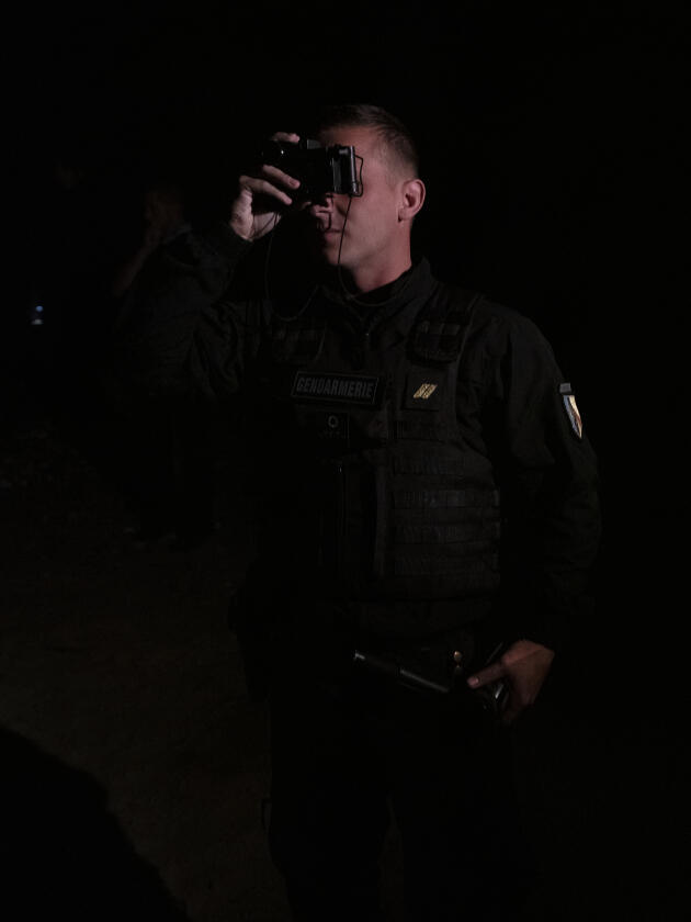 Un officier de la gendarmerie mobile utilise une paire de jumelle à vision nocturne lors d’une patrouille à Calais.
