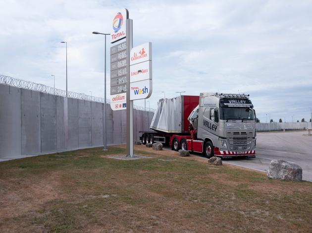 La station d'essence Total s'est équipée d'un mur anti-intrusion de 5 mètres de haut et de barbelés pour éviter les passagers clandestins dans les camions vers l'Angleterre.