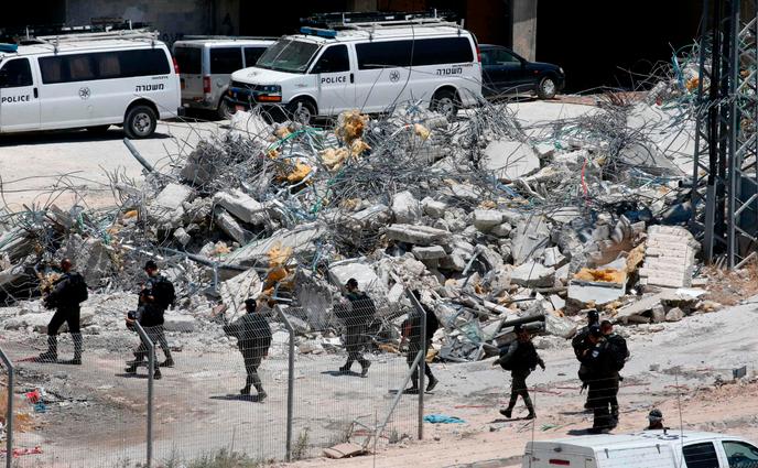 Les forces de sécurité israéliennes marchent devant les décombres d’une maison qui a été démolie, à Dar Salah, en Cisjordanie, le 22 juillet.