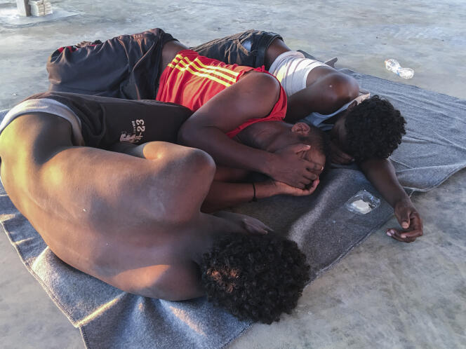 Des migrants secourus se reposent sur une côte, à environ 100 kilomètres à l’est de Tripoli, en Libye, le 25 juillet.
