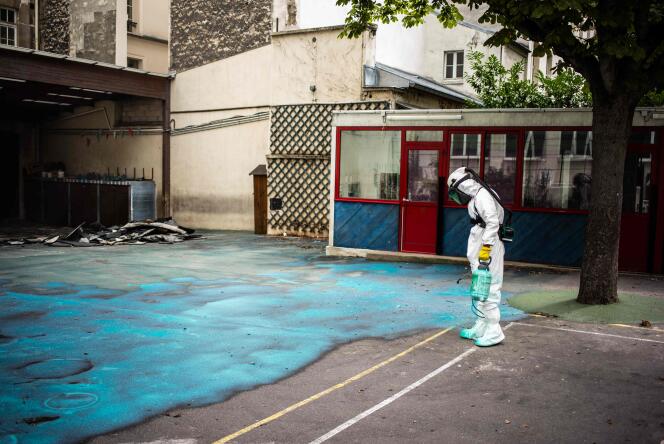 Un ouvrier réalise les travaux de décontamination des cours du groupe scolaire Saint-Benoît, dans le 6e arrondissement de Paris, le 8 août.