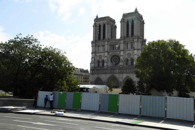 Les ouvriers installent des palissades devant la cathédrale Notre-Dame de Paris avant les travaux de décontamination du 13 août 2019.