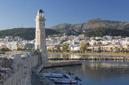 View along sea wall of the Venetian Harbour, 16th century lighthouse prominent, Rethymno (Rethymnon), Crete, Greek Islands, Greece, Europe