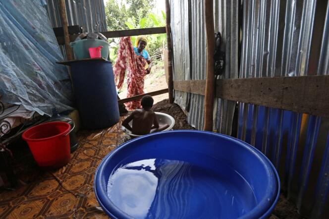 Une femme donne le bain à son fils dans une maison en tôle à Mamoudzou, à Mayotte en 2013.