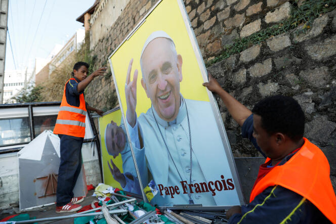 Des agents municipaux accrochent un portrait du pape François à Antanarivo, le 27 août 2019.
