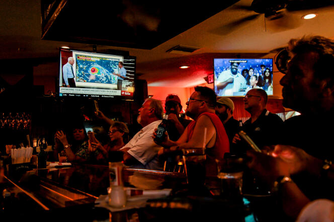 Des touristes et des habitants de Floride suivent les informations sur l’ouragan Dorian, dans un bar de St. Augustine, en Floride, le 31 août.