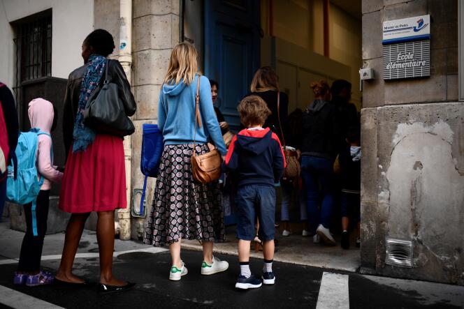 Des parents emmènent leurs enfants dans une école à Paris, le 2 septembre.