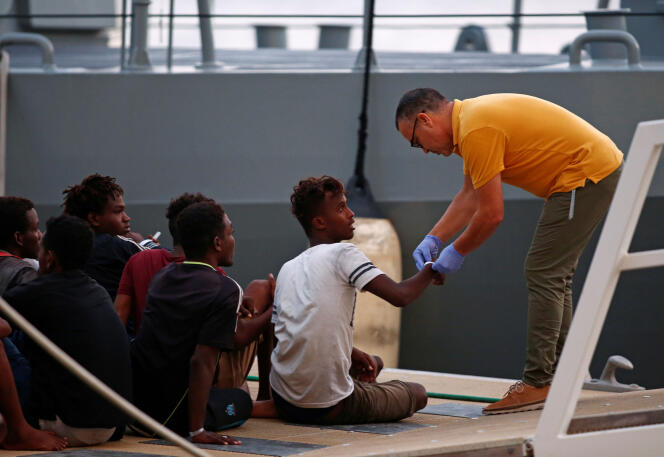 Un agent de police s’occupe de migrants débarqués au port de La Valette, à Malte, le 21 septembre.