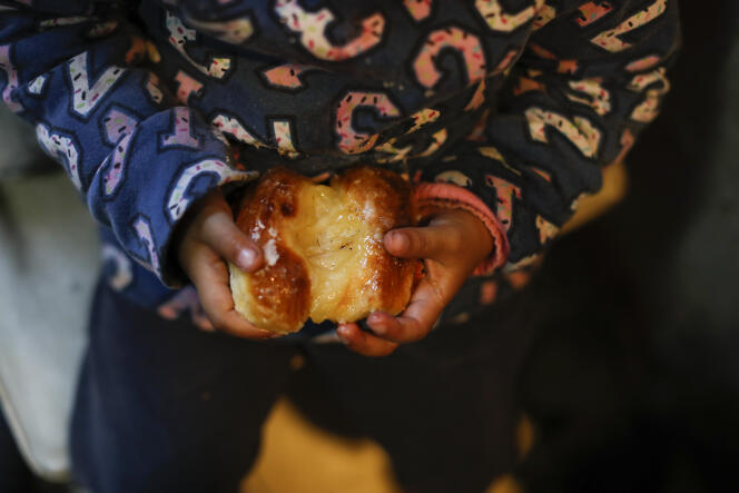 Une fillette tient une pâtisserie dans une soupe populaire de la banlieue de Buenos Aires, en Argentine, le 17 septembre.