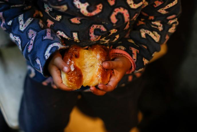 Une fillette tient une pâtisserie dans une soupe populaire de la banlieue de Buenos Aires, en Argentine, le 17 septembre.