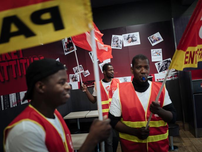 Mamadou, au centre, tient un drapeau, au KFC de place d'Italie, le 1er octobre.