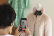 Une femme prend des photos de vêtements pour les vendre avec l'application Vinted