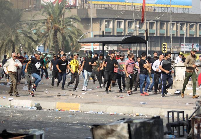 Des manifestants fuient la police antiémeute, à Bagdad, le 3 octobre.