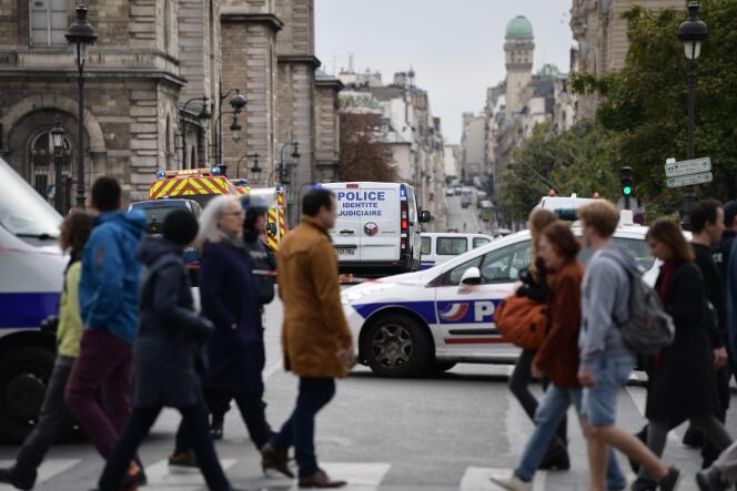 Des passants devant le siège de la police parisienne après que quatre personnes ont été tuées dans une attaque au couteau, à Paris, le 3 octobre.