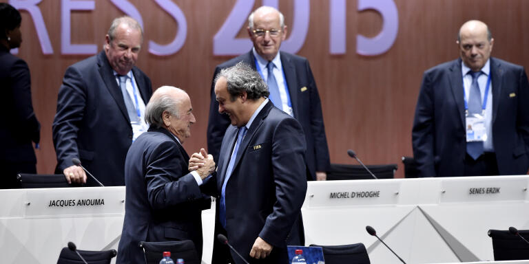 FIFA President Sepp Blatter (Foreground-L) shakes hands with UEFA president Michel Platini after being re-elected following a vote to decide on the FIFA presidency in Zurich on May 29, 2015.   Sepp Blatter won the FIFA presidency for a fifth time after his challenger Prince Ali bin al Hussein withdrew just before a scheduled second round.    AFP PHOTO /  MICHAEL BUHOLZER (Photo by MICHAEL BUHOLZER / AFP)