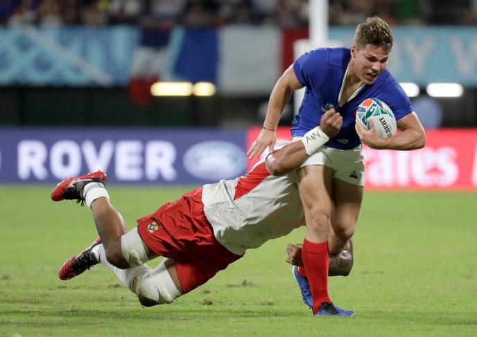 Rugby La défense tongienne tentant de transformer le col rond du maillot français en col en V.