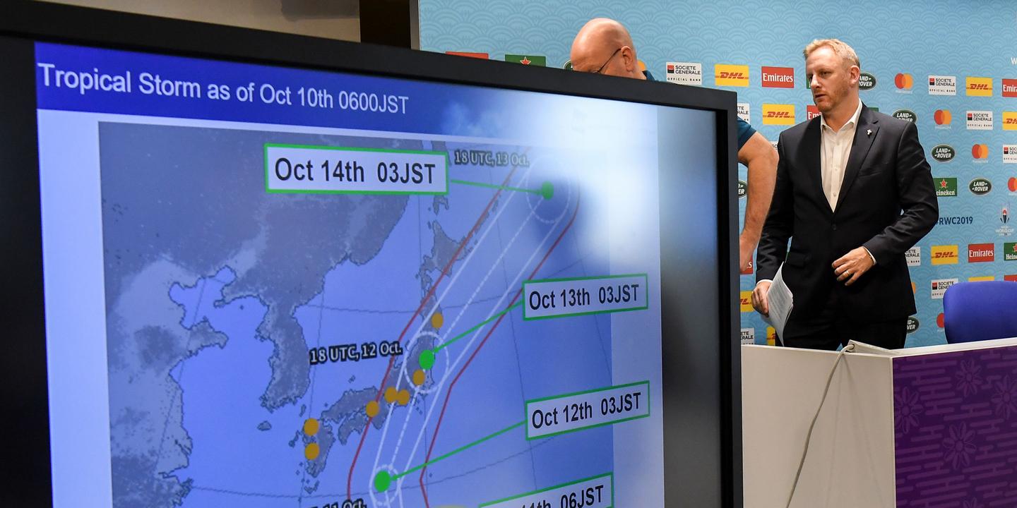 Rugby William West / AFP Rugby Tournament director of the Japan 2019 Rugby World Cup Alan Gilpin (R) walks past a screen showing the path of the approaching typhoon Hagibis, which will affect upcoming World Cup matches, in Tokyo on October 10, 2019. Rugby World Cup organisers took the unprecedented step of cancelling games -- England v France, and New Zealand v Italy -- on October 10 as Super Typhoon Hagibis bears down on Japan. / AFP / William WEST