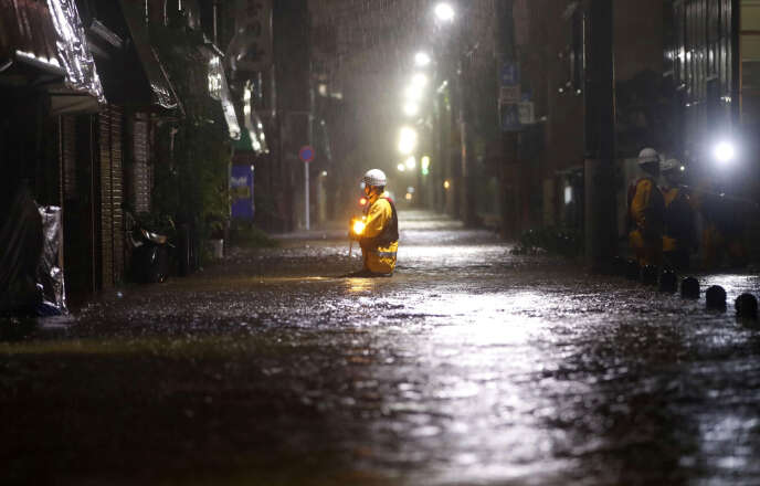 Des pompiers patrouillent sur une route inondée du quartier d’Ota, à Tokyo, le 12 octobre. KYODO / REUTERS