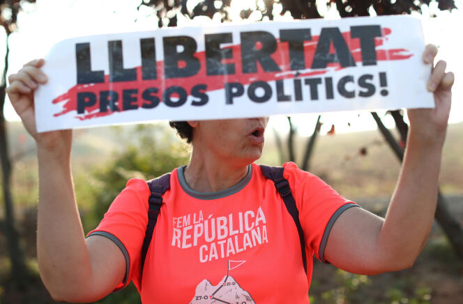 Une femme brandit une banderole indiquant « Libérez les prisonniers politiques » devant la prison de Lledoners, à Sant Joan de Vilatorrada (Catalogne), où des dirigeants catalans emprisonnés attendent le verdict de leur procès, le 14 octobre 2019.