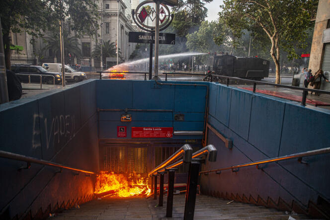 La police utilise un canon à eau pour éteindre une barricade enflammée, au-dessus de la station de métro Santa Lucia, à Santiago du Chili, le 18 octobre.