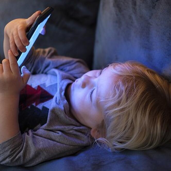 Un enfant regardant un smartphone.