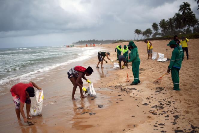 Des employés municipaux nettoient les résidus de pétrole sur la plage Barra de Jacuipe à Camacari, dans l’Etat de Bahia, le 22 octobre.