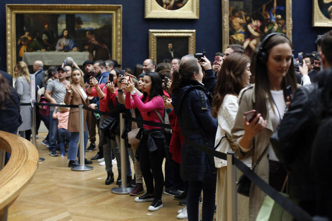Des visiteurs photographient « La Joconde », le chef-d’œuvre de Léonard de Vinci, au musée du Louvre à Paris, le 23 octobre.