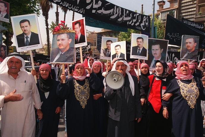 Des paysans syriens de la province de Daraa, à une centaine de kilomètres au sud de Damas, manifestent dans la capitale syrienne, le 9 juillet 2000, pour soutenir le président en exercice, Bachar Al-Assad, un jour avant le plébiscite présidentiel.