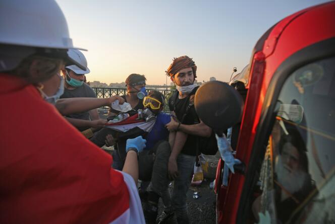 Des manifestants aident un camarade blessé près du pont Al-Sinak, à Bagdad, le 1er novembre.