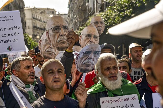 A Alger, le 1er novembre, des manifestants agitent des masques où est imprimé le visage de Lakhdar Bouregaa, un vétéran arrêté à l’été.