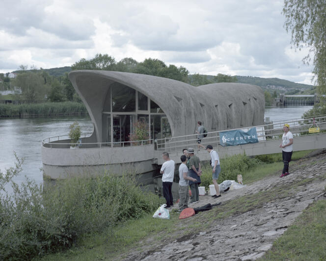 Des touristes pêchent près du Centre européen à Schengen, Luxembourg, en juillet.