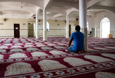 A man prays in a room of the mosque of Tsingoni, on the French island of Mayotte on September 14, 2019. - Degraded ceiling, infiltrations during the rainy season, cracks, corrosion of metallic elements, molds due to humidity and dust: the old room of the oldest mosque in France, in Tsingoni, Mayotte, is under renovation. In Tsingoni, the former royal capital in the center of Mayotte, followers like Abdillahi Salim continue to make their five daily prayers in this room with white and blue sky walls. (Photo by Ali AL-DAHER / AFP)