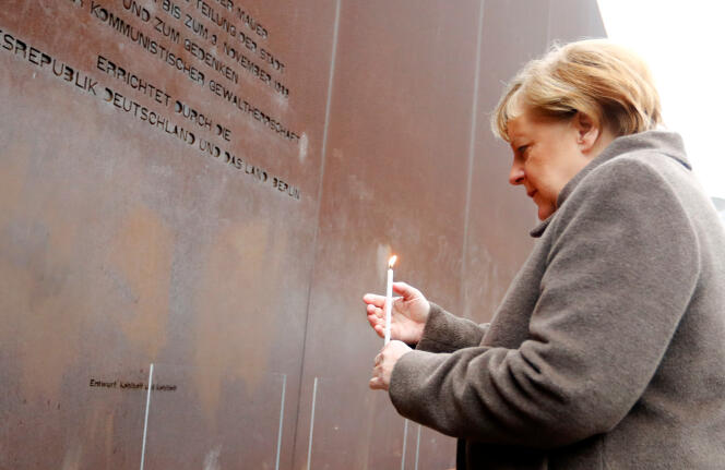 La chancelière allemande, Angela Merkel, allume une bougie devant un Mémorial en l’honneur des victimes du communisme, le 9 novembre 2019, à Berlin.