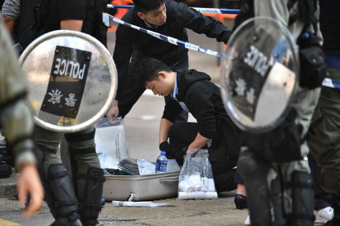 Des policiers recueillent des indices sur le site où des manifestants se sont fait tirés dessus par la police antiémeute, à Hongkong, le 11 novembre.