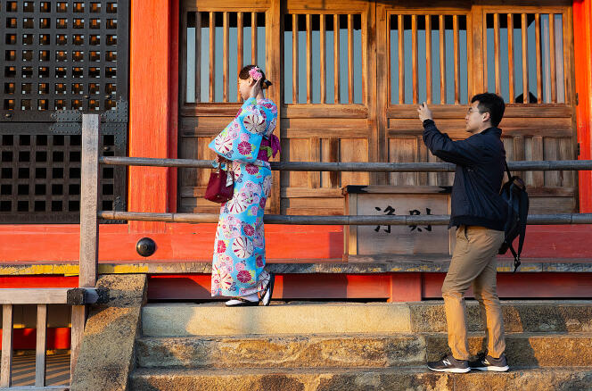 Un touriste photographie son amie habillée en kimono au temple Kiyomizu-dara, le 31 octobre à Kyoto.