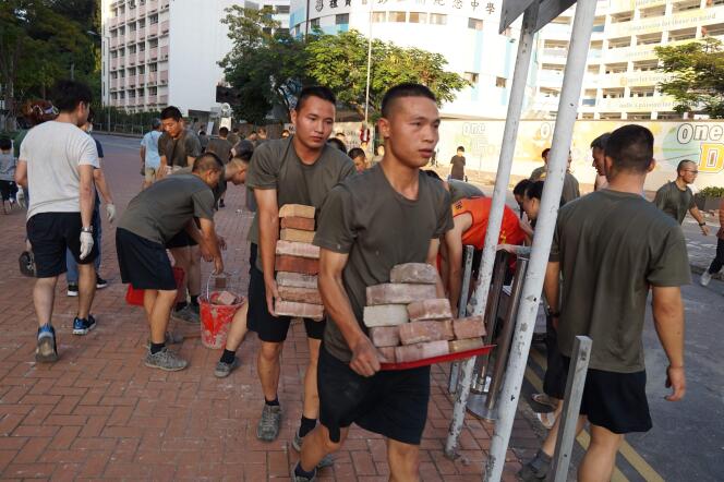 Des membres de l’armée chinoise participent au nettoyage des rues de Hongkong, samedi 16 novembre.